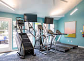 Thumbnail 20 of 31 - A gym with treadmills, elliptical machines, and a stair climber.