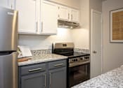 Thumbnail 3 of 31 - A kitchen with a stove and refrigerator.