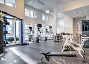 Thumbnail 20 of 22 - A gym with a variety of equipment including weights and cardio machines.