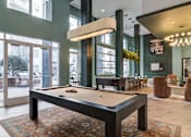 Thumbnail 11 of 22 - A pool table is in the middle of a room with a green wall and a large window.