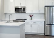 Thumbnail 11 of 50 - White counter top, cabinets in kitchen area at Icon Apartment Homes at Ferguson Farm, Montana