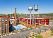 Thumbnail 1 of 33 - A red brick building with a water tower and a pool.