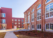 Thumbnail 17 of 33 - A red brick building with a walkway in front.
