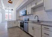 Thumbnail 13 of 33 - A kitchen with white cabinets and a granite countertop.