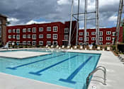 Thumbnail 27 of 33 - A swimming pool in front of a red brick building.