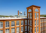 Thumbnail 32 of 33 - A red brick building with a water tower on top.