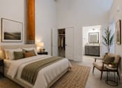 Thumbnail 6 of 33 - A bedroom with a large bed and a chair.
