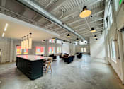 Thumbnail 24 of 33 - A large open space with a kitchen island and multiple seating areas.
