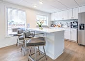 Thumbnail 3 of 22 - A kitchen with a white island and a refrigerator at Waterview at Rocky Point, Tampa, FL