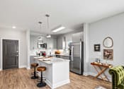 Thumbnail 7 of 48 - A modern kitchen with a white island and stools.
