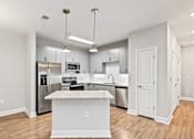 Thumbnail 9 of 48 - A kitchen with a white island in the middle.