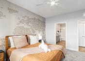 Thumbnail 18 of 48 - A bedroom with a bed, a ceiling fan, and a wall with a world map.