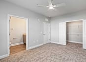 Thumbnail 19 of 48 - A room with a ceiling fan and a carpeted floor.