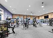 Thumbnail 23 of 48 - A spacious gym with a variety of equipment including treadmills, weights, and exercise machines.