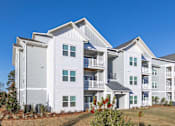 Thumbnail 44 of 48 - A large white residential building with multiple balconies and windows.