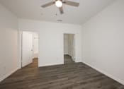 Thumbnail 15 of 35 - A room with a ceiling fan and wooden flooring.