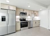Thumbnail 5 of 40 - A modern kitchen with a refrigerator, microwave, oven, and sink.