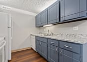 Thumbnail 22 of 29 - a kitchen with blue cabinets and a white refrigerator