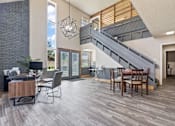 Thumbnail 4 of 18 - a living room with a dining room table and a staircase