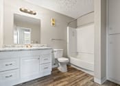 Thumbnail 8 of 18 - a bathroom with white cabinets and a toilet and a tub