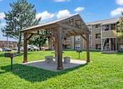 Thumbnail 16 of 18 - a picnic area with a bench in front of an apartment building