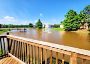 Thumbnail 18 of 22 - A wooden deck overlooks a flooded area with a bridge and buildings in the distance.