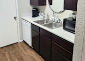 Thumbnail 7 of 22 - A small kitchen with a white door and a white sink.