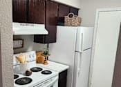 Thumbnail 6 of 22 - A kitchen with a white stove top oven and a white refrigerator.
