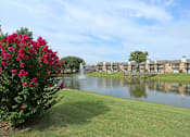 Thumbnail 4 of 11 - A beautiful view of a lake surrounded by buildings and a fountain.