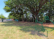 Thumbnail 6 of 11 - A green metal sculpture of a dog is in a grassy area.