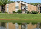 Thumbnail 3 of 11 - A building with a pond in front of it.