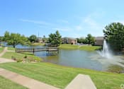 Thumbnail 7 of 11 - A park with a pond and a fountain.