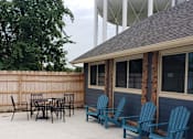Thumbnail 9 of 29 - A patio with blue chairs and a table.