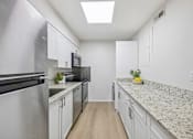 Thumbnail 3 of 17 - A kitchen with granite countertops and stainless steel appliances.