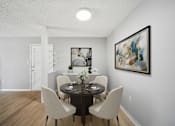 Thumbnail 9 of 17 - A dining room with a table set for two and a painting on the wall.