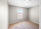 Thumbnail 6 of 14 - A room with a window and carpeted floor.