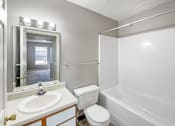 Thumbnail 7 of 14 - A white bathroom with a toilet, sink, and bathtub.