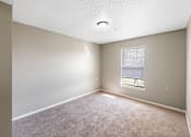 Thumbnail 13 of 14 - A room with a window and carpeted floor.
