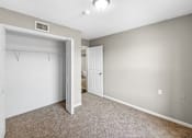 Thumbnail 5 of 14 - A room with a white door and a carpeted floor.