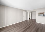 Thumbnail 8 of 14 - A room with wooden flooring and white walls.