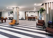 Thumbnail 21 of 40 - A black and white striped floor in a room with a long table and chairs.