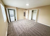 Thumbnail 34 of 35 - A room with a carpeted floor and a white refrigerator.