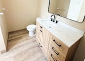 Thumbnail 35 of 35 - A bathroom with a wooden vanity and a mirror above it.