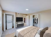 Thumbnail 6 of 35 - A bedroom with a bed, a television, and a refrigerator.