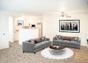 Thumbnail 27 of 35 - A living room with grey couches and a coffee table.