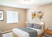 Thumbnail 10 of 35 - A bedroom with a bed, nightstand, and two paintings on the wall.