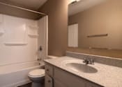 Thumbnail 14 of 35 - A bathroom with a toilet, sink, and mirror.