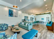Thumbnail 34 of 49 - a large living room with blue couches and chairs and a kitchen with a bar at Imperial Crossing Luxury Apartment Homes, Bonita Springs, FL