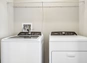 Thumbnail 18 of 71 - Two white front loading washing machines in a laundry room.