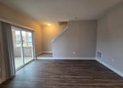 Thumbnail 27 of 57 - Townhome living area with walkout patio and stairs leading to second level s at Flats at Sugar Run Apartments, Delaware, OH